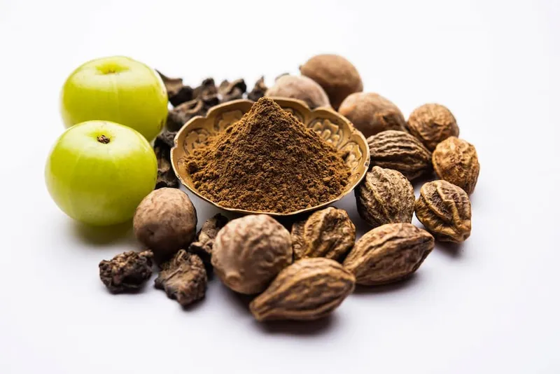 Triphala churna and Amla ingredients used in Ayurveda, showing natural herbs commonly recommended as the best ayurvedic medicine for fatty liver.